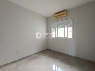 Vista interna de uma sala com paredes brancas e piso de cerâmica.