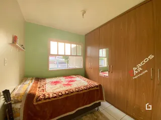 Quarto com cama e armário de madeira na sala.