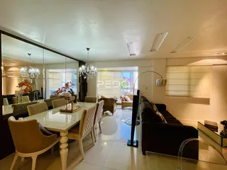 Sala de jantar iluminada com mesa de madeira e cadeiras em um imóvel no Brasil.