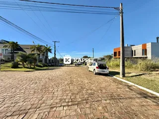 Vista externa da propriedade mostrando a entrada pavimentada e o entorno.