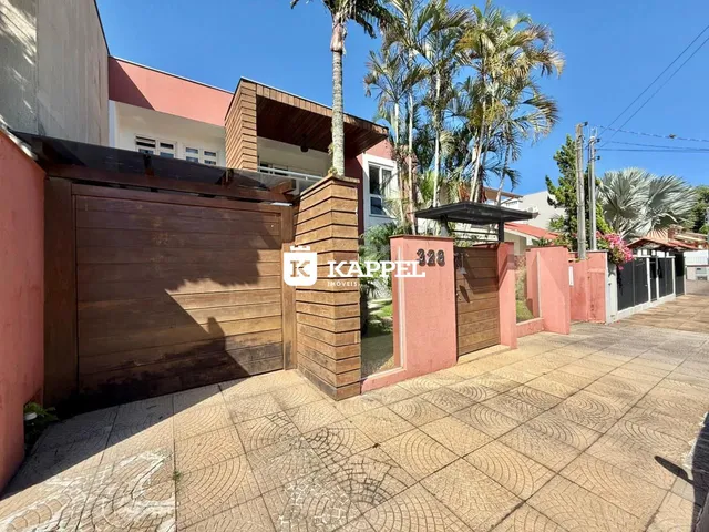 Fachada externa de uma residência em Lajeado, Brasil, com garagem e muro de alvenaria.