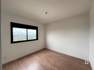 Sala de estar com piso de madeira e grande janela.