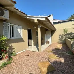 Fachada externa de uma residência em Lajeado, Brasil, com revestimento de estuque e telhado de telhas.