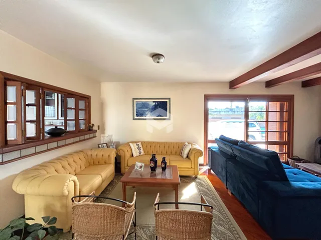 Sala de estar com sofás amarelos e azuis e piso de madeira.
