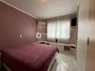 Quarto com cama e paredes em tom de rosa claro.