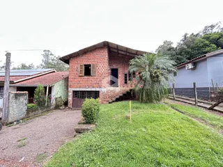 Fachada de uma casa de tijolos com jardim gramado.