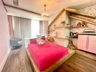 Quarto com decoração rosa e cabeceira de madeira em um apartamento no Brasil.