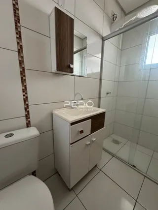 Foto de um banheiro com revestimento cerâmico e box de vidro.