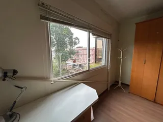 Vista de uma janela de um cômodo interno com vista para a vegetação.