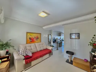 Sala de estar com sofá e pintura na parede em um imóvel no Brasil.