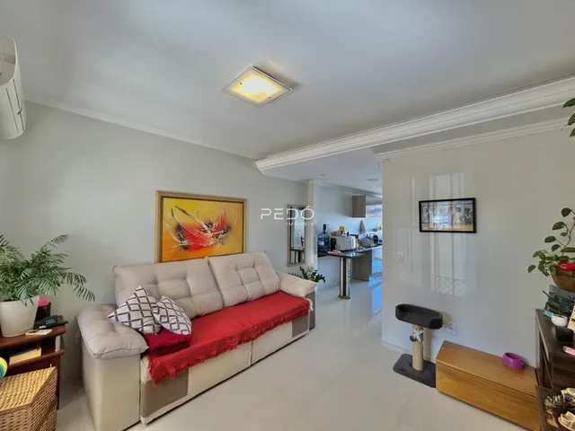 Sala de estar com sofá e pintura na parede em um imóvel no Brasil.