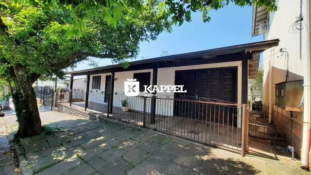 Fachada de uma residência em Lajeado, Brasil, com cerca e vegetação.