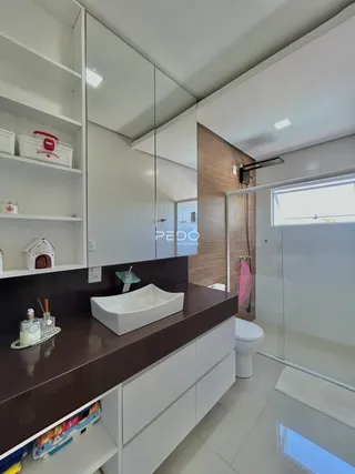 Banheiro com bancada escura e revestimento branco na Lajeado, Brasil.