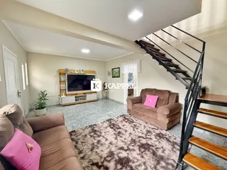 Sala de estar com sofá e televisão em ambiente interno.