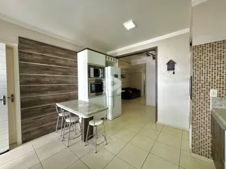 Ambiente interno de uma sala de jantar com mesa e cozinha em Lajeado, Brasil.