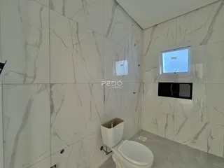 Banheiro com revestimento de azulejos brancos com padrão de mármore.