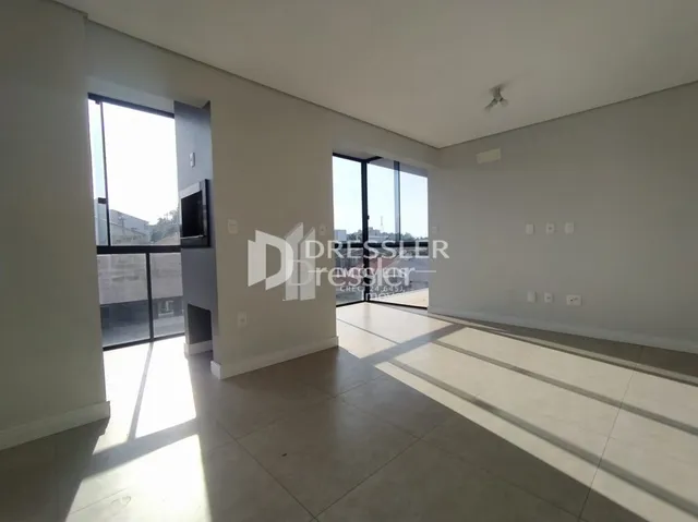 Vista interna de um ambiente com paredes brancas e piso claro.