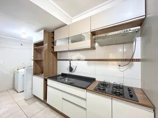 Cozinha moderna com armários brancos e bancada escura.