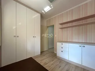 Quarto com armários embutidos e piso de madeira clara.