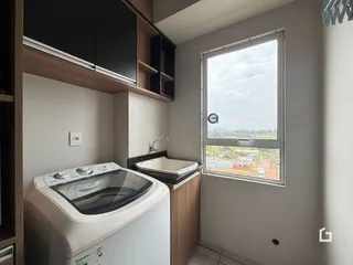 Foto de uma área de serviço com máquina de lavar e janela.