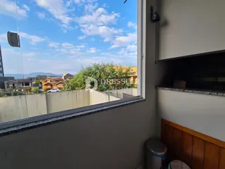 Vista da paisagem com árvores e casas ao longe.
