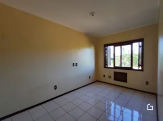 Ambiente interno de uma sala com piso de cerâmica e parede amarelada.