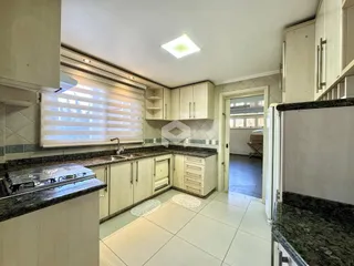 Foto de uma cozinha com armários brancos e bancadas escuras.