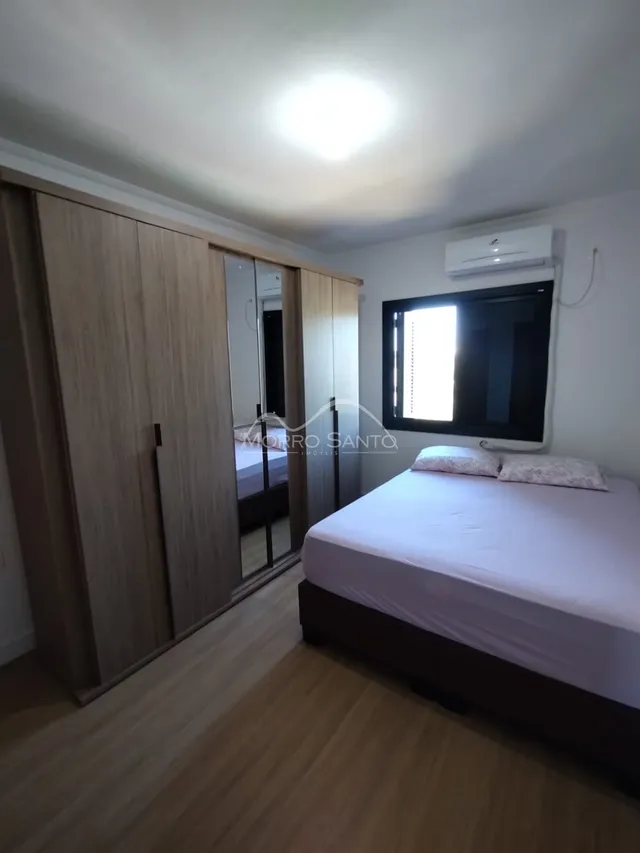 Quarto com cama e armário de madeira em um imóvel.