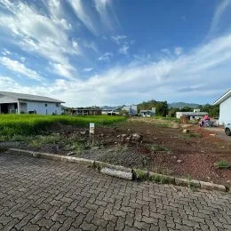 Vista externa de um terreno com terra e pavimentação.