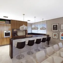 Foto de uma cozinha com bancada de madeira e banquetas.