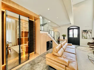 Sala de estar moderna com portas de vidro e sofá de couro marrom.