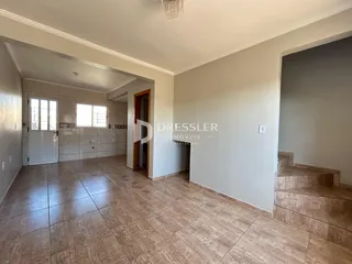 Hall de entrada com piso de cerâmica e paredes claras.