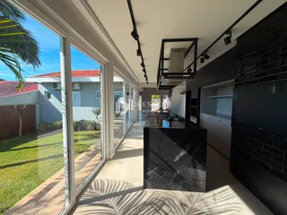 Sala de estar com vista para o jardim através de grandes portas de vidro.