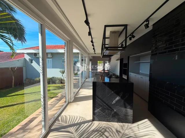Sala de estar com vista para o jardim através de grandes portas de vidro.