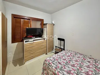 Quarto com cabeceira e armários de madeira em um imóvel no Brasil.