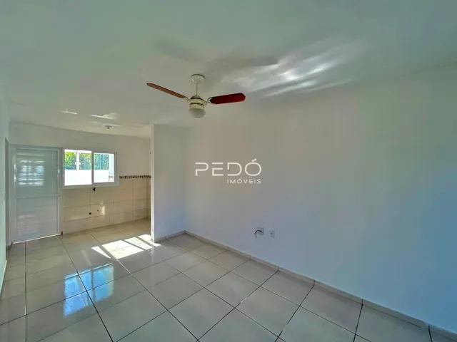 Interior de uma sala com piso de cerâmica e janela.