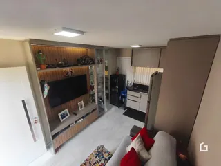 Interior de uma sala com estantes de madeira e sofá.