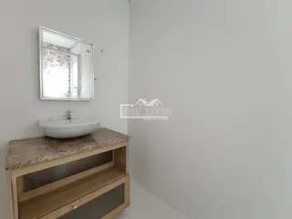 Banheiro com pia de apoio e móvel de madeira na área de Lajeado.