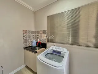 Foto da cozinha mostrando armários e uma máquina de lavar roupa.