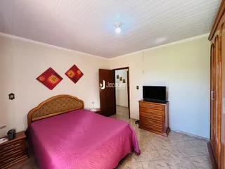 Quarto com cama e cabeceira de madeira em um imóvel no Brasil.