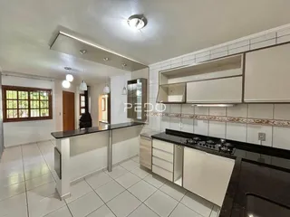 Foto de uma cozinha com armários brancos e piso de cerâmica.