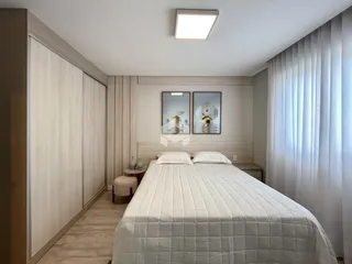 Quarto moderno com cabeceira e armário embutido.