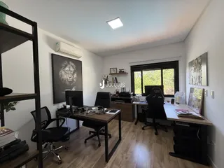 Ambiente de escritório com piso de madeira e grandes janelas em Lajeado.