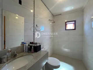 Banheiro com revestimento de cerâmica e bancada de granito.