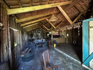 Interior rústico com vigas de madeira expostas e teto alto.
