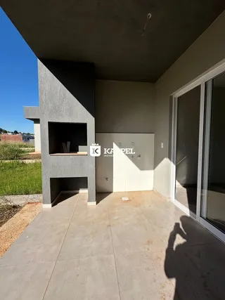 Uma foto da fachada externa de uma residência em Lajeado, mostrando um pátio de concreto.