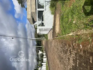 Vista externa de uma residência moderna em Lajeado, Brasil, ao lado de uma estrada de terra.