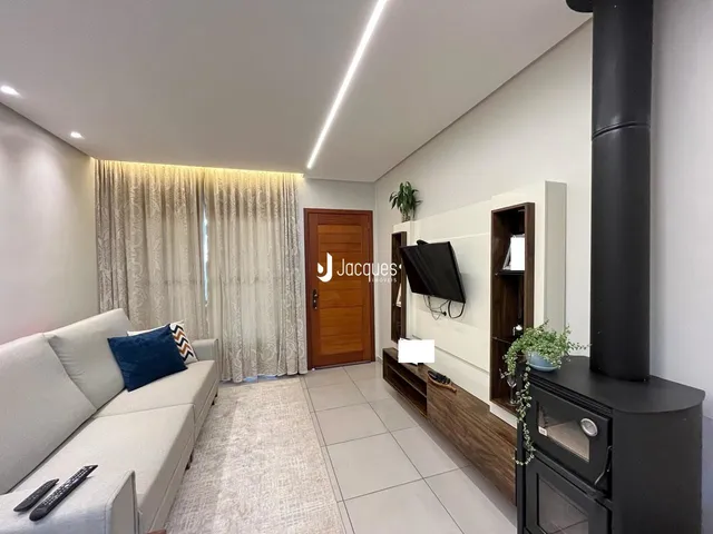 Sala de estar com sofá e cortinas em um apartamento.