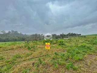 Paisagem de campo com vegetação e um sinal no meio.