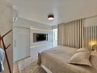 Quarto com cama e cortinas em um apartamento.